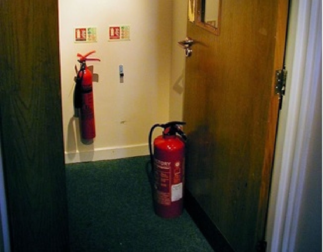 fire extinguisher being used to prop open door
